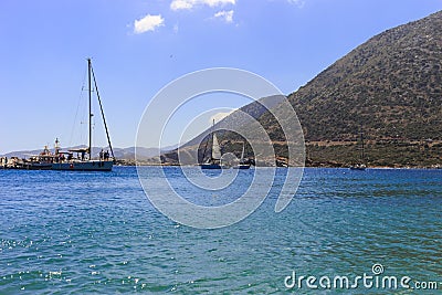 White sailboat in the open sea. Sailing yacht in the open sea with mountains in the background. Editorial Stock Photo