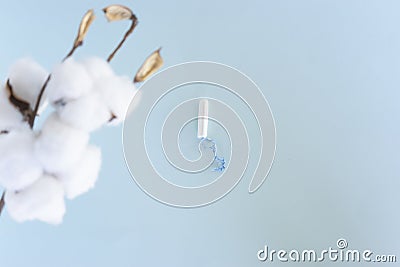 A white sanitary tampon lie on a blue background Stock Photo