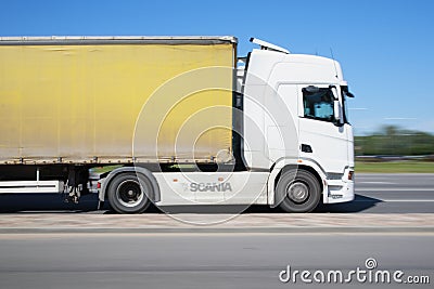 A white Scania S pulls a semi-trailer down the street. Side view. Motion blur. Riga, Latvia - 15 Jun 2021 Editorial Stock Photo