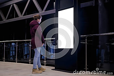 White screen concept - woman looking at blank interactive white display kiosk Stock Photo