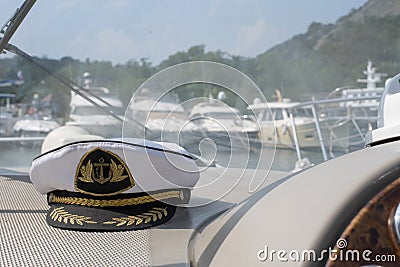 White sea captain`s cap on the dashboard of the boat Stock Photo