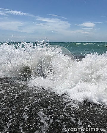 White sea foam on the shore of the blue sea. Stock Photo