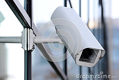 White security cctv camera on glass facade Stock Photo