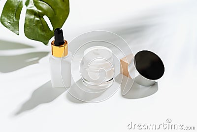 White serum bottle and cream jar, mockup of beauty product brand. Top view on the white background. Stock Photo
