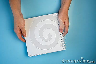 white sheet of Notepad in two hands, copyspace Stock Photo
