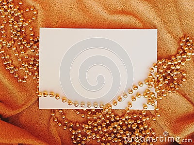 WHITE SHEET OF PAPER ON color FABRIC WITH GOLD HOLIDAY BEADS Stock Photo