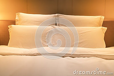 White sheets king size bed with double pillows with warm light Stock Photo