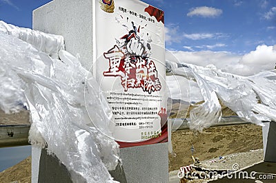 White silk scarves blow wildly next to a sign asserting Chinese government control over the people Editorial Stock Photo