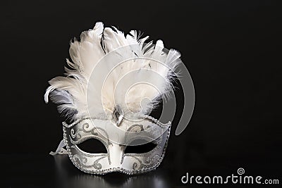 White and silver venetian carnival mask with feathers on a black background Stock Photo