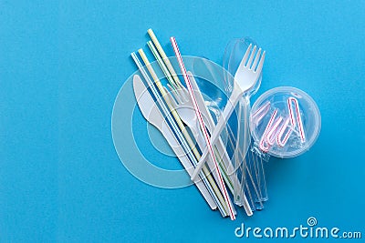 White single-use plastic and plastic drink straws on a blue background. Say no to single use plastic Stock Photo