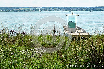 White small motor boat with cabin and steering wheel moored on the shore Stock Photo