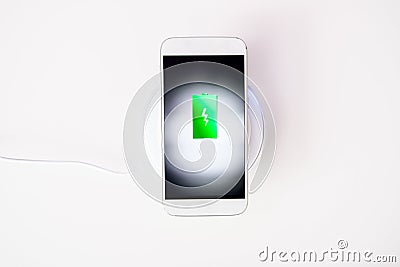 White smartphone charged by wireless charger Stock Photo