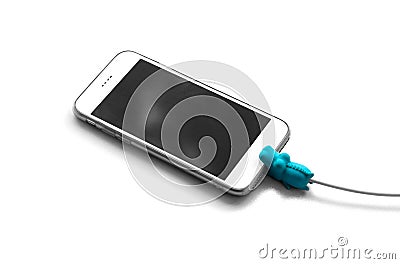 The white smartphone is connected to the wired charging. On the wire toy in the form of a blue crocodile. Close up. Isolated on wh Stock Photo