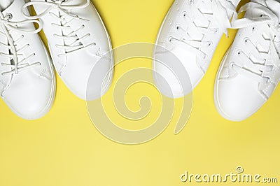 White sneakers on yellow background top view flat lay. Stylish youth women`s leather sneakers, sports shoes, genuine leather Stock Photo