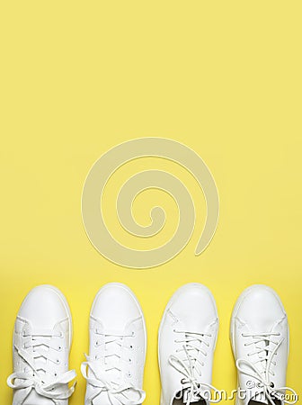 White sneakers on yellow background top view flat lay. Stylish youth women`s leather sneakers, sports shoes, genuine leather Stock Photo