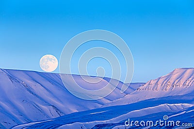 White snowy mountain with Moon, blue glacier Svalbard, Norway. Ice in ocean. Iceberg twilight in North pole. Pink clouds with ice Stock Photo