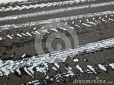 White snowy tires imprints on black asphalt road Stock Photo
