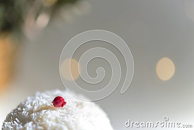 White soft one portion cake with grated coconuts and a red sugar top of it, macro Stock Photo