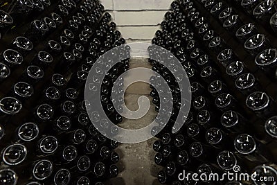 White sparkling wine bottles in the cellars of winery, sparkling wine fermenting on stands Stock Photo