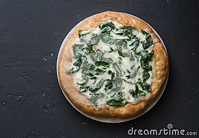 White spinach mozzarella pizza on a dark background Stock Photo