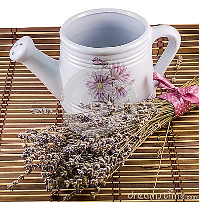 White sprinkler, watering can and a bouquet of Lavandula flowers Stock Photo