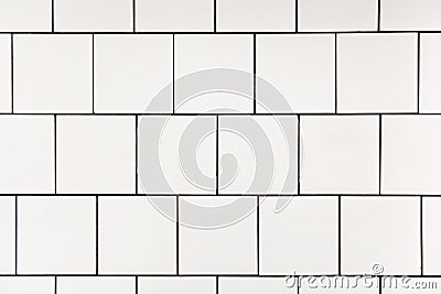 White square ceramic tile with black seam, located horizontally. Abstract background, ceramic texture. Stock Photo