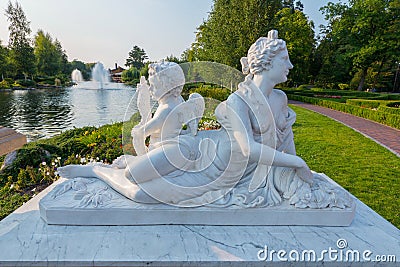 White statue of a lying woman with an angel on the shore near the lake in the park. Novi Petrivtsi, Ukraine Editorial Stock Photo
