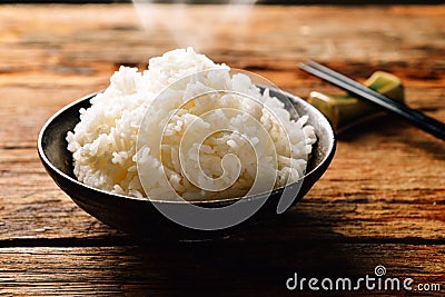White steamed rice in round bowl on wooden table and chopsticks Stock Photo