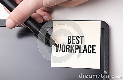 white sticker on the monitor in the office with text BEST WORKPLACE and hand with marker Stock Photo