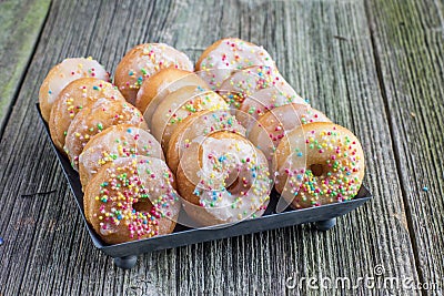 White sugar glazed mini donuts on a sheet metal tray Stock Photo