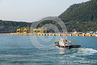 White super structure and black hull tugboat sails in the Bang Saphan industrial port Editorial Stock Photo