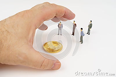 On a white surface, bitcoin, miniature figures of people and a human hand that reaches for bitcoin. Stock Photo