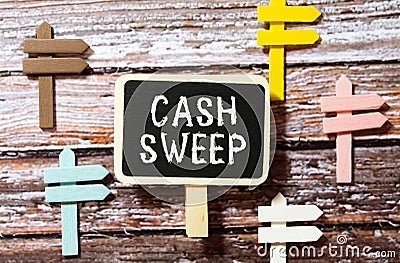 On a white surface are twisted dollars, a notebook and a cardboard sign with the inscription - Cash sweep Stock Photo