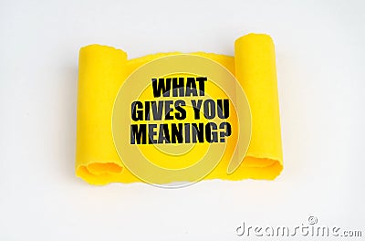 On a white surface, a yellow scroll of paper with the inscription - WHAT GIVES YOU MEANING Stock Photo