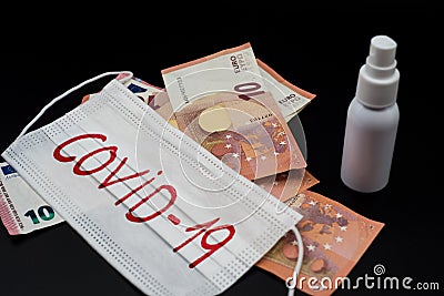 White surgical mask with covid word written on red, euro banknotes and bottle of disinfectant. Concept pandemic crisis of covid Stock Photo