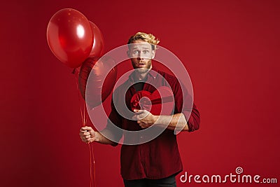 White surprised man posing with balloons and heart gift box Stock Photo