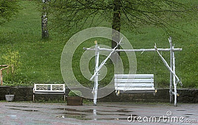White swings in the garden after the summer rain. Stock Photo