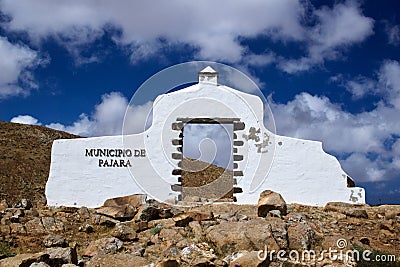 White symbolic wall with a doorway and a territory name sign in a dry landscape Stock Photo