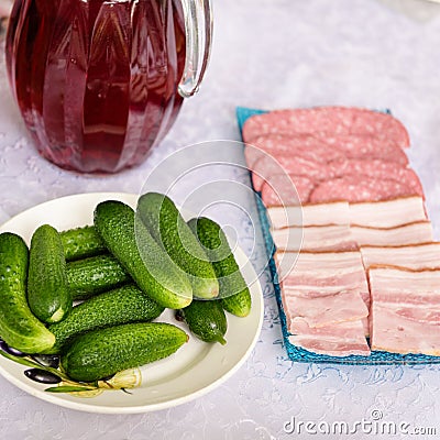 On a white table lies a snack for vodka, in the form of fresh cucumbers Stock Photo
