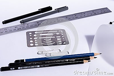 White table with roll paper. Pencils and pens with rulers and clips on an architect`s desk. Stock Photo