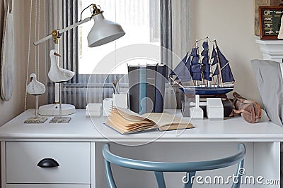 White table with wooden chair books and lamp in modern working area Stock Photo