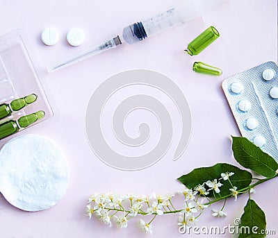 White tablets, glass ampoules, a syringe and cherry blossoms are arranged on a white background. Spring allergy Stock Photo