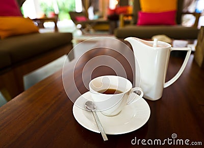 White tea pot and cup on the table Stock Photo