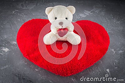 White teddy bear with love letter on red heart gray background. Say i you for valentine `s day concept. Stock Photo