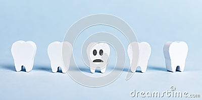 White teeth row and one with sad emoji. Poor oral hygiene, dental problems, periodontal disease, caries concept. Tooth Stock Photo