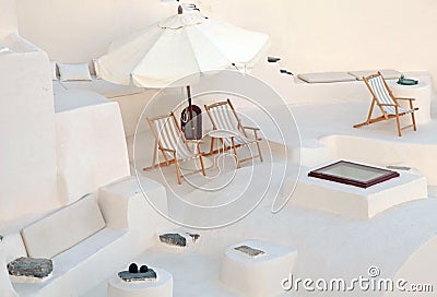 White terrace with deck chairs in caldera house, Santorini, Gree Stock Photo