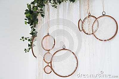 White textured bedroom in the style of shabby. Bed in an ecological style and Loft style. Rustic dream catchers on a white wall. Stock Photo