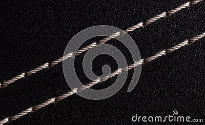 White thread stitching on black leather. Stock Photo