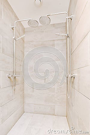 a white tiled bathroom with a shower and two Stock Photo