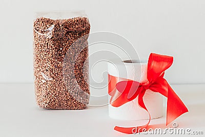 White toilet paper with a red bow on a white background. Buckwheat Stock Photo